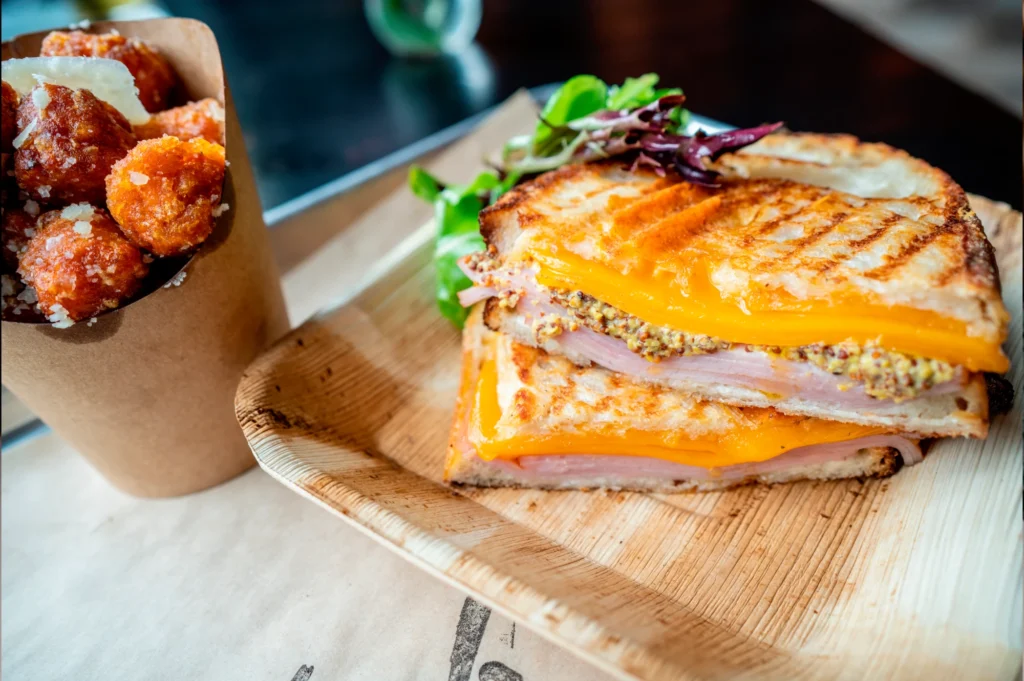 a cut in half sandwich sitting on top of a wooden cutting board